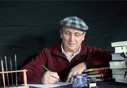 A picture of a writer working with pencils and books